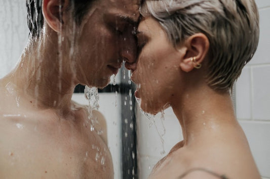 Couple under the shower with a sensual contact head to head